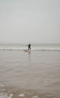 Rear view of woman surfing in sea