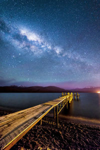 Scenic view of jetty against sky at night