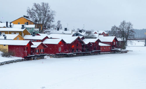 Porvoo, finland, december 2021. old wooden red houses by the frozen river porvoonjoki