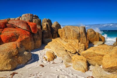 Rocks on beach against clear blue sky