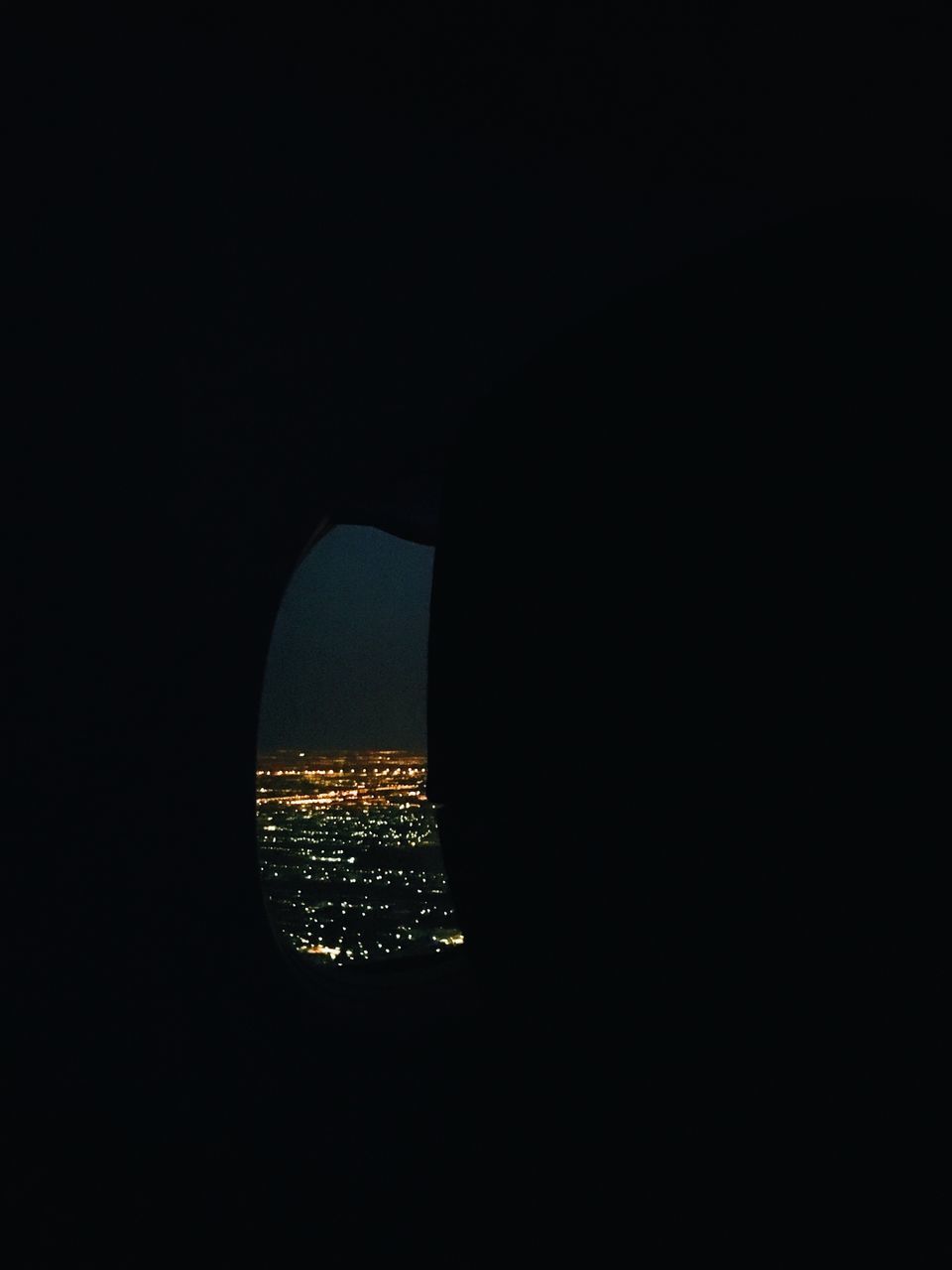 ILLUMINATED CITYSCAPE BY SEA AGAINST SKY SEEN THROUGH DARK