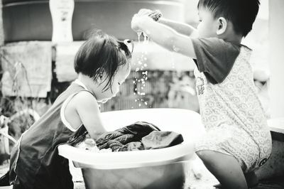 Cute siblings washing clothes