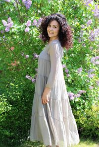 Portrait of smiling woman standing against plants