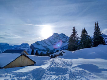 Scenic view of snowcapped mountains against bright sun