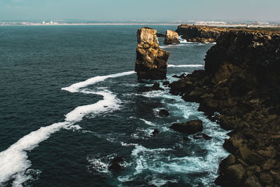 Rock formations in sea against sky