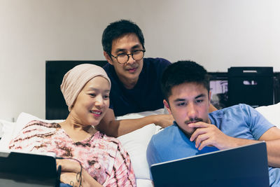 Portrait of smiling family using digital tablet while sitting at home