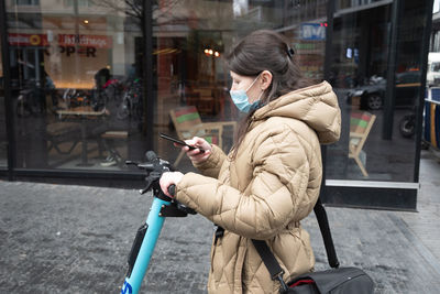 Brussels belgium - 01.31.2022 a young woman in a warm down jacket and a mask