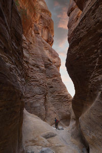 Hiker with backpack walking on wadi ghuweir canyon in dana natural reserve, jordan