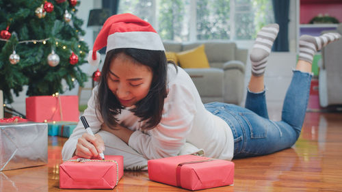 Full length of girl sitting on christmas tree