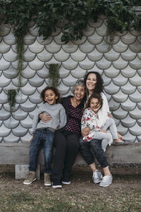 Portrait of multigenerational family sitting and smiling outside