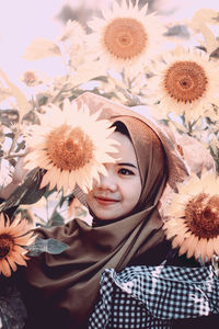 Portrait of young woman holding flower, sunflowers 