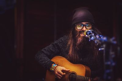 Hipster singing while playing guitar