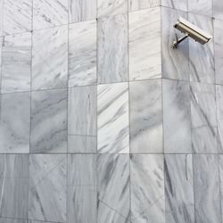 Low angle view of security camera on marble wall