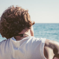 Rear view of man in sea against clear sky