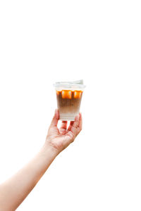 Cropped hand holding drink against white background