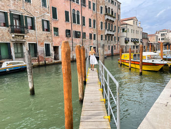 Woman wearing white dress walking on the pier in venice