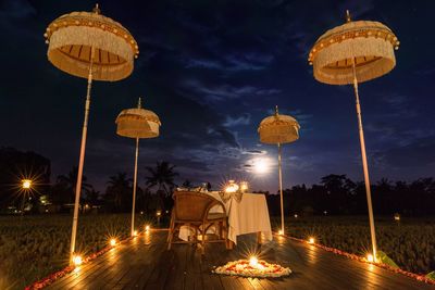 Lit candles with heart shaped decoration by dinning table on porch at night