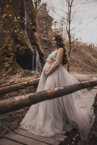 Rear view of woman standing against trees