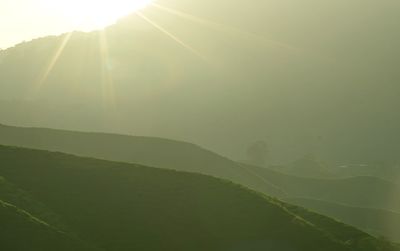 Sunlight streaming through clouds over landscape