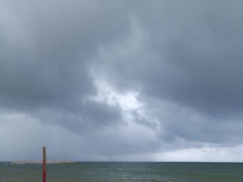 Scenic view of sea against storm clouds