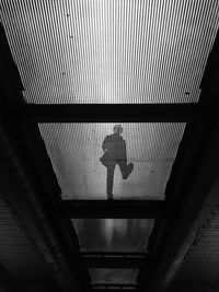 Low angle view of person walking on iron footbridge