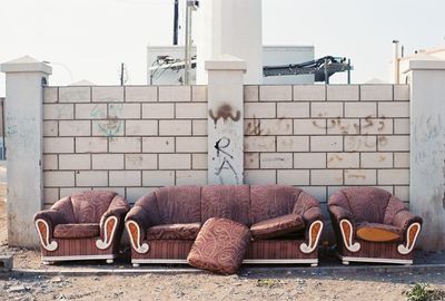 Abandoned couch against wall