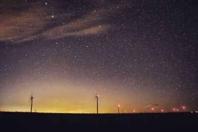 Low angle view of illuminated field against star field