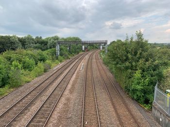 Railroad tracks by trees against sky