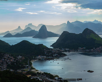 Scenic view of sea and mountains against sky