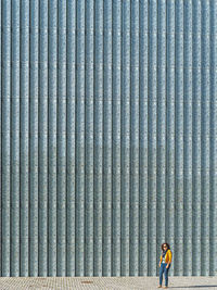 Side view of woman walking against wall