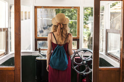 Rear view of woman standing in vehicle