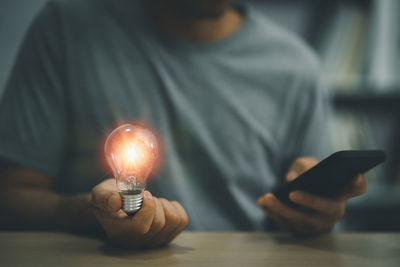 Midsection of man using mobile phone