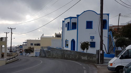 Road by buildings against sky in city