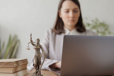 Portrait of woman using laptop while sitting on table