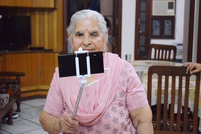 Senior woman taking selfie at home