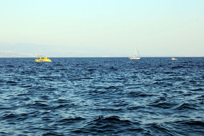 Sailboat sailing on sea against clear sky