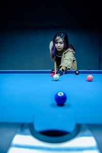 Young woman playing pool