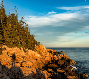 Rock formations by sea against sky