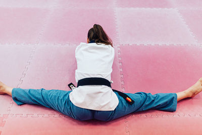 Rear view of woman stretching at gym