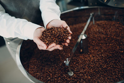 Midsection of man holding coffee beans