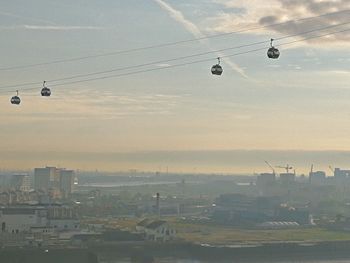 Overhead cable cars against sky