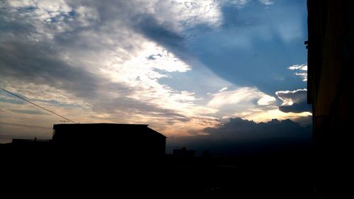 Buildings against cloudy sky at sunset