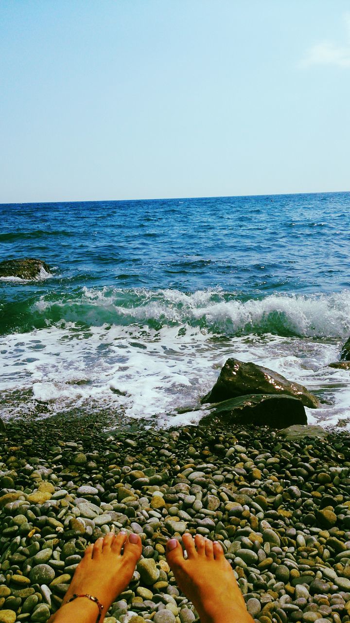 water, sea, beach, horizon over water, low section, clear sky, person, shore, scenics, beauty in nature, tranquility, personal perspective, tranquil scene, nature, barefoot, sky, copy space