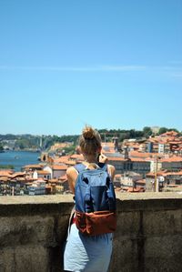 Rear view of woman standing against cityscape