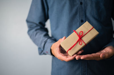 Midsection of man holding paper