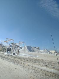 Scenic view of road amidst field against clear sky