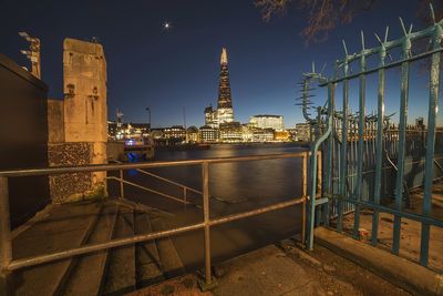 Shard london bridge by thames river against sky in city at night