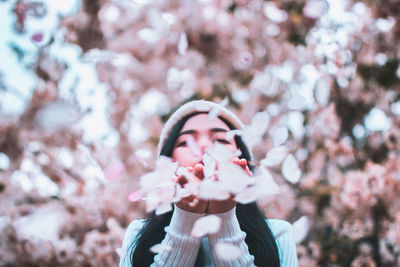 Young woman amidst flowering trees