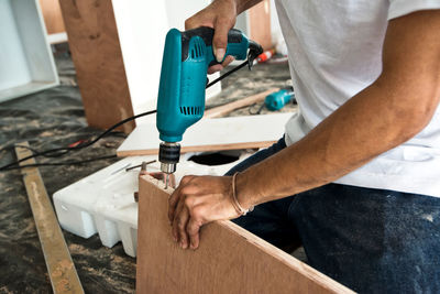 Midsection of man working on wood