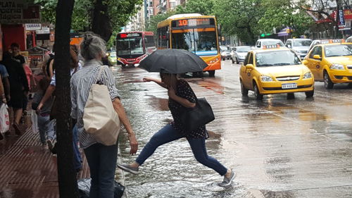 People walking on wet street in city